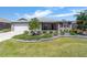 Inviting home with a well-manicured lawn, decorative shrubs, and a charming facade at 8820 Sw 104Th Cir, Ocala, FL 34481
