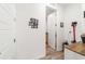 Hallway with vinyl flooring, featuring an open door and wall decorations at 8820 Sw 104Th Cir, Ocala, FL 34481