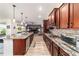 This kitchen features stainless steel appliances, granite countertops, and dark wood cabinetry at 8820 Sw 104Th Cir, Ocala, FL 34481