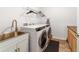 Functional laundry room with stainless steel sink, modern washer and dryer, and neutral decor at 8820 Sw 104Th Cir, Ocala, FL 34481
