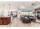 Open-concept living room featuring a large sectional, coffered ceiling, and expansive windows at 8820 Sw 104Th Cir, Ocala, FL 34481