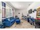 Comfortable living room featuring a blue sofa set, a large window, and a mounted television at 8820 Sw 104Th Cir, Ocala, FL 34481