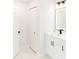 Bright bathroom with white cabinets, modern vanity, tiled floor, and bi-fold closet doors at 8878 Sw 133Rd Lane Rd, Ocala, FL 34473