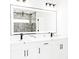 Modern bathroom boasts double sinks, sleek black hardware, and a large, lighted mirror at 8878 Sw 133Rd Lane Rd, Ocala, FL 34473
