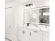 This bathroom features a double sink vanity with black hardware and a lighted mirror at 8878 Sw 133Rd Lane Rd, Ocala, FL 34473