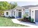Charming home showcasing a landscaped front yard, gray paint, and a modern front door at 8878 Sw 133Rd Lane Rd, Ocala, FL 34473