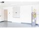 Clean garage featuring epoxy flooring, water heater, and secondary interior door at 8878 Sw 133Rd Lane Rd, Ocala, FL 34473