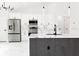 Modern white kitchen featuring stainless steel appliances, marble countertops, and an island with sink and faucet at 8878 Sw 133Rd Lane Rd, Ocala, FL 34473