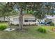View of the backyard featuring a patio with grill and outdoor seating, framed by a mature tree and lush lawn at 9015 Sw 94Th St # D, Ocala, FL 34481