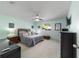 Bright bedroom featuring a ceiling fan, light blue walls, and a comfortable bed with nautical-themed decor at 9015 Sw 94Th St # D, Ocala, FL 34481