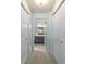 Hallway with closet storage leading to a bathroom with grey vanity and great lighting at 9015 Sw 94Th St # D, Ocala, FL 34481