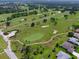 Aerial view of the community golf course and surrounding neighborhood and trees at 9290 Se 120Th Loop, Summerfield, FL 34491