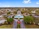 Aerial view of community entrance featuring a fountain roundabout, lush landscaping, and a welcoming entryway at 9290 Se 120Th Loop, Summerfield, FL 34491