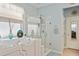Well-lit bathroom with separate glass shower and tub with blue walls at 9290 Se 120Th Loop, Summerfield, FL 34491