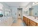 Bathroom with double sinks, walk-in shower, and a separate tub at 9290 Se 120Th Loop, Summerfield, FL 34491