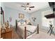 A quaint bedroom features a ceiling fan, wooden bed frame, and a window bringing in natural light at 9290 Se 120Th Loop, Summerfield, FL 34491