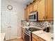 Close-up of kitchen featuring wooden cabinets, stainless steel appliances and mosaic backsplash at 9290 Se 120Th Loop, Summerfield, FL 34491