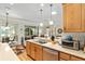 Kitchen with stainless steel dishwasher, double sink, wood cabinets and pendant lighting at 9290 Se 120Th Loop, Summerfield, FL 34491