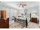 Bedroom with blue walls, ceiling fan, carpet, and a large window for natural light at 9290 Se 120Th Loop, Summerfield, FL 34491