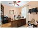 This home office boasts a ceiling fan, wood flooring, and a large wooden desk with built in bookshelves at 9290 Se 120Th Loop, Summerfield, FL 34491