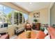 Bright sunroom featuring large windows, comfortable seating, and neutral decor; perfect for relaxation and enjoying natural light at 9290 Se 120Th Loop, Summerfield, FL 34491