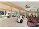 Relaxing sunroom with ceiling fans, bamboo blinds, and comfortable seating, perfect for enjoying the backyard view at 9290 Se 120Th Loop, Summerfield, FL 34491