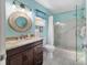 Bathroom with a modern vanity, decorative mirror, glass-enclosed shower and tiled floors at 9331 Sw 84Th Ter # C, Ocala, FL 34481