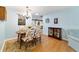 Charming dining area featuring a chandelier, table set for four, and hardwood floors at 9331 Sw 84Th Ter # C, Ocala, FL 34481