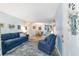 Comfortable living room featuring a blue sofa, area rug, and light blue walls that continue into the dining room at 9331 Sw 84Th Ter # C, Ocala, FL 34481