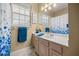 Bathroom featuring a vanity with blue accents under a mirror and a shower curtain at 9579 Sw 195 Cir, Dunnellon, FL 34432