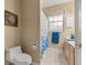 Cozy bathroom featuring a toilet, vanity with blue accents and a shower curtain at 9579 Sw 195 Cir, Dunnellon, FL 34432