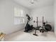 Bright exercise room featuring a treadmill and weightlifting equipment next to a window with plantation shutters at 9579 Sw 195 Cir, Dunnellon, FL 34432