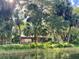Waterfront property featuring mature trees and a covered outdoor living area for relaxing and entertaining by the river at 9579 Sw 195 Cir, Dunnellon, FL 34432