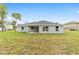 Exterior back view of the home featuring a spacious yard and covered patio at 9709 Sw 40Th Ct, Ocala, FL 34476