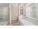 Bright bathroom featuring glass shower enclosure, soaking tub, and neutral tile at 9709 Sw 40Th Ct, Ocala, FL 34476
