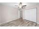 Bright bedroom featuring laminate floors, ceiling fan, and a closet at 9709 Sw 40Th Ct, Ocala, FL 34476