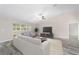 Open living room with vaulted ceiling, neutral tones, wood flooring, comfortable seating, and ample natural light at 9709 Sw 40Th Ct, Ocala, FL 34476