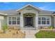 The home's front entrance features decorative columns, a dark wood door, and well-manicured landscaping at 9957 Sw 55Th Avenue Rd, Ocala, FL 34476