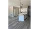 Kitchen with center island, white cabinetry, stainless faucet, and pendant lighting overlooking the living area at 11537 Sw 59Th Ter, Ocala, FL 34476