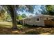 Charming single-story home featuring a covered porch and a mature tree providing shade at 1858 Se Lake Weir Ave, Ocala, FL 34471