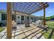 Stone patio with pergola and white wicker seating at 2563 Se 156Th Place Rd, Summerfield, FL 34491