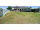 Spacious backyard with lawn, stone patio, pergola and house at 2563 Se 156Th Place Rd, Summerfield, FL 34491