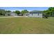The exterior of a charming house with a green lawn and a detached garage at 2563 Se 156Th Place Rd, Summerfield, FL 34491
