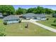 Front exterior of home with green lawn, large driveway and detached garage at 2563 Se 156Th Place Rd, Summerfield, FL 34491