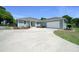 Landscaped front yard with circular driveway leading to garage at 2563 Se 156Th Place Rd, Summerfield, FL 34491