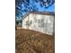 Shows the side of the home with white textured walls, a door, and surrounding yard at 32 Spring Loop Circle, Ocala, FL 34472
