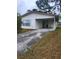 Home's facade includes a driveway, window, and covered parking at 32 Spring Loop Circle, Ocala, FL 34472