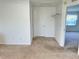 A carpeted bedroom features neutral walls, and a door leading to an adjoining room at 4998 Nw 30Th Pl, Ocala, FL 34482
