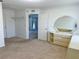 Bright bedroom featuring neutral walls, carpeted floor, and dresser with large mirror at 4998 Nw 30Th Pl, Ocala, FL 34482