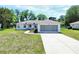 Charming home featuring a screened garage, well-kept lawn, and a welcoming walkway to the front door at 4998 Nw 30Th Pl, Ocala, FL 34482